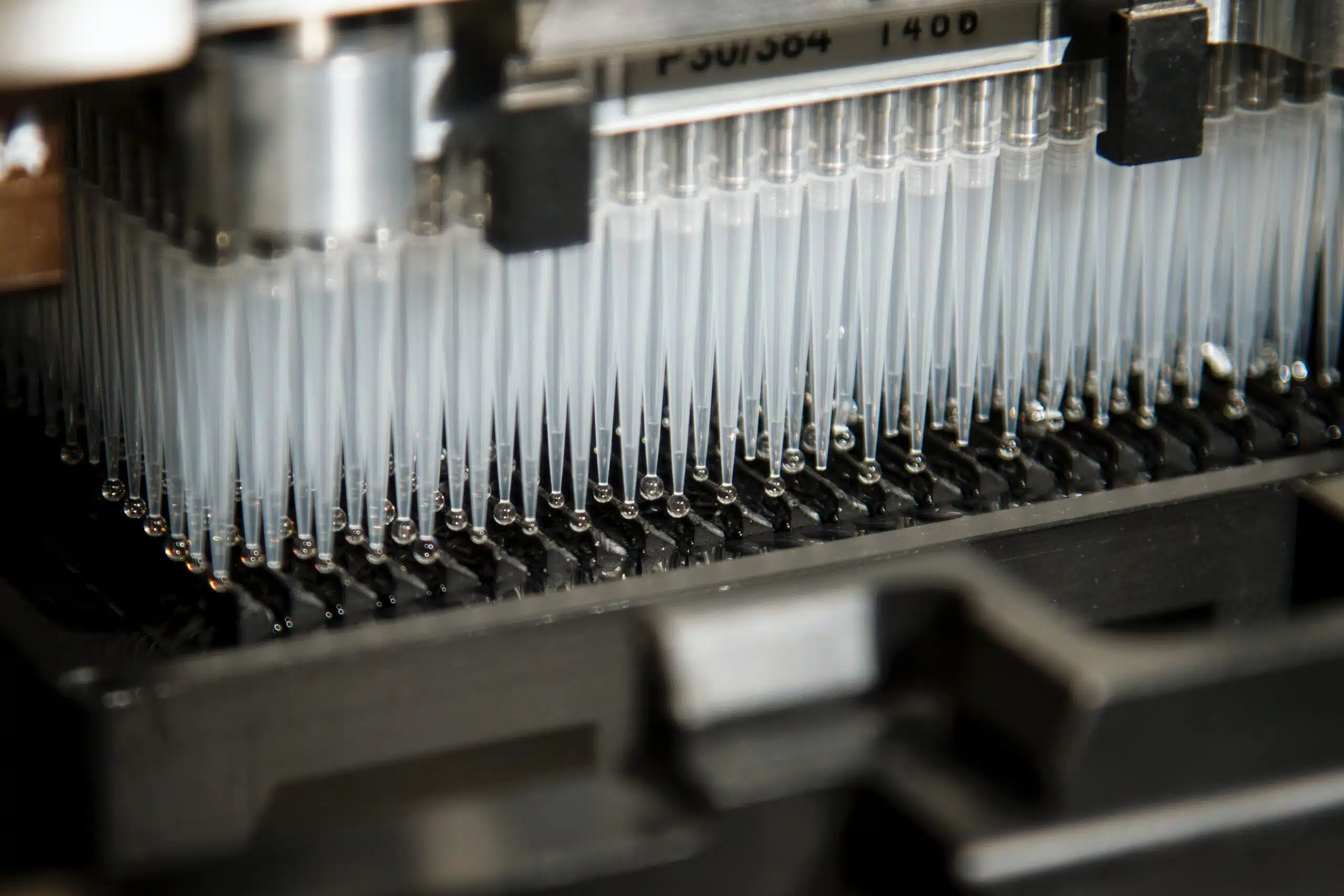 Photo of a gray lab machine with pipettes by National Cancer Institute on Unsplash.