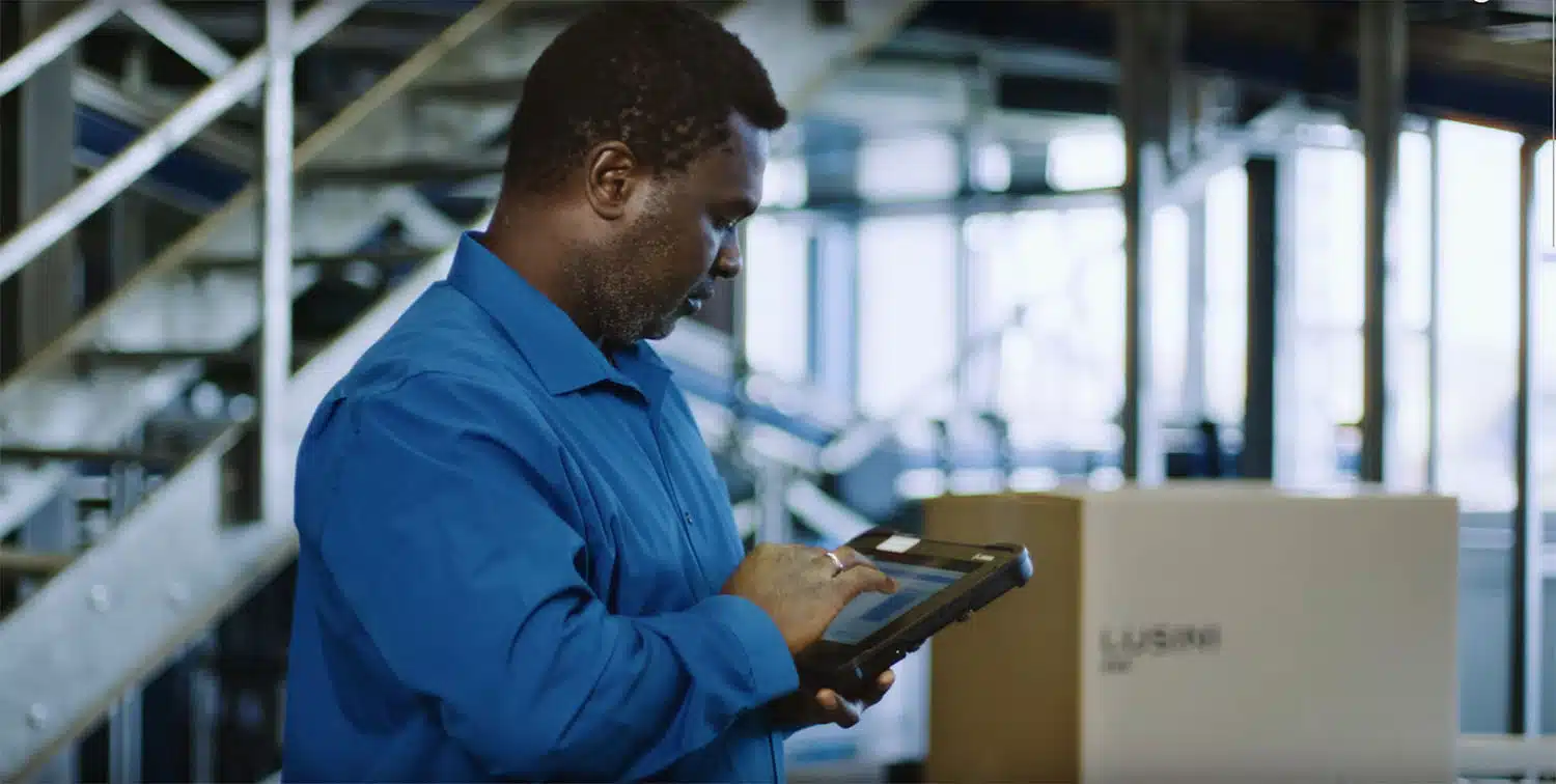 Developer retrieves information via a tablet MDT next to a conveyor line.