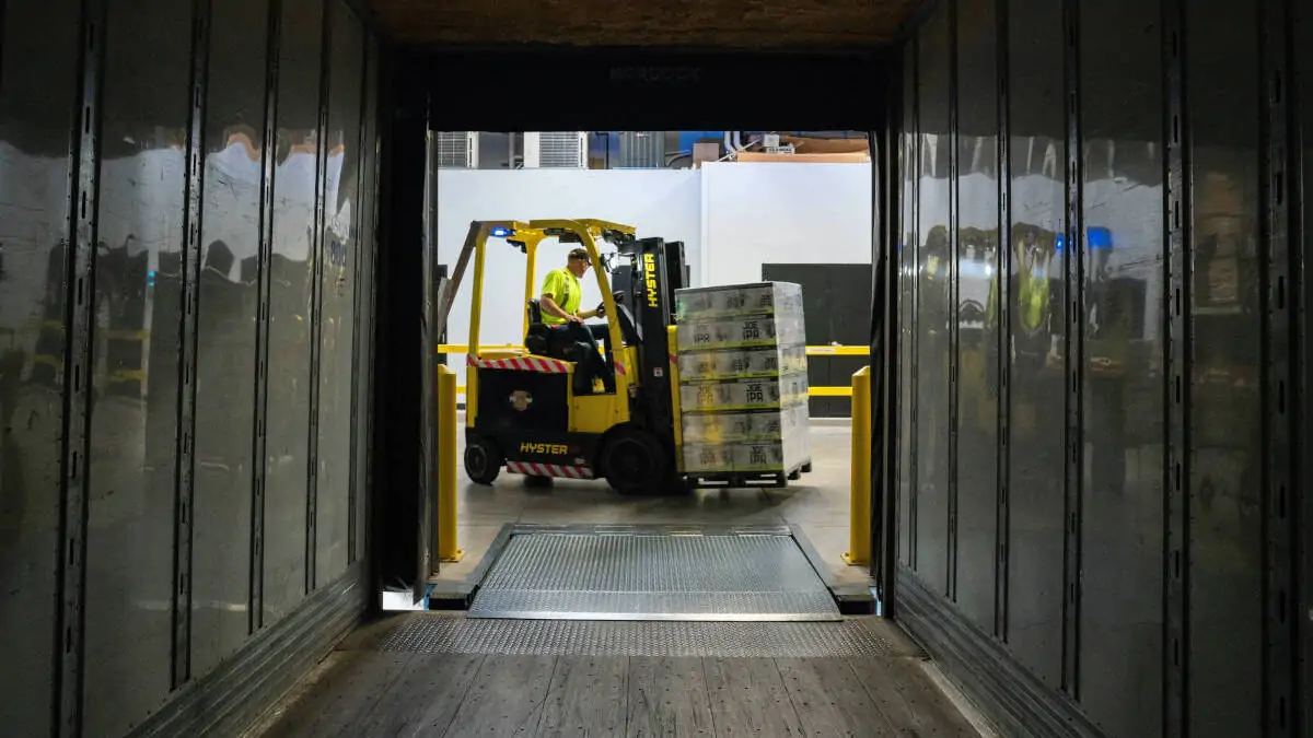 Forklift truck loading paletts of merchandise on a truck trailer. Photo by Elevate on Unsplash